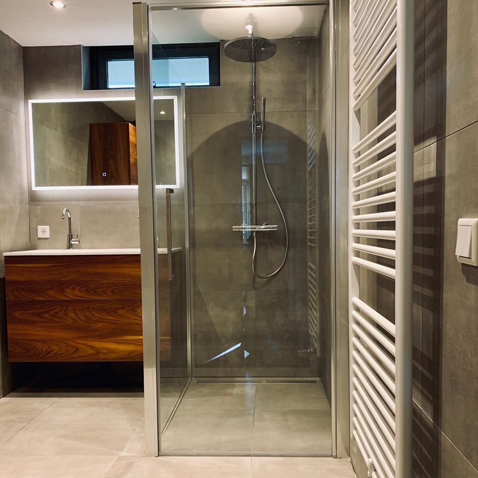 Moderne badkamer met bruin badkamermeubel spiegel met verlichting glazen douchewand en verwarming